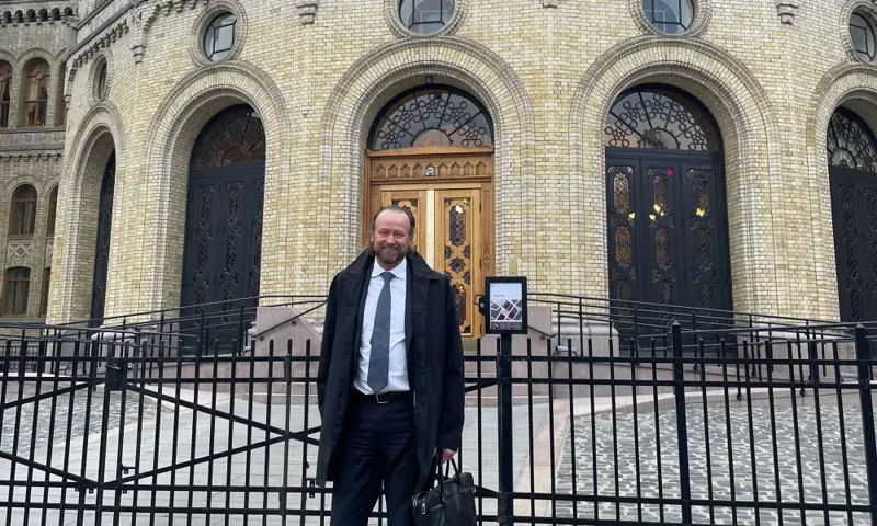 Photo of a man standing in front of a building